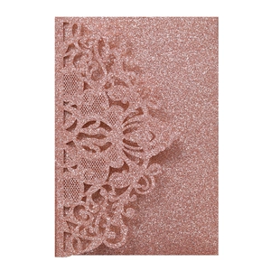 Detail of rose gold glitter laser cut wedding invitation with lace floral pattern