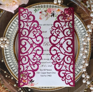 Intricate laser-cut glitter pink wedding invitation with floral insert and pearls