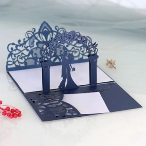Detail of laser-cut 3D wedding invitation with navy blue lace gate and couple silhouette