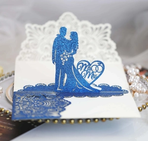 Dettaglio dell'invito di nozze blu glitterato tagliato al laser con scritte Mr & Mrs
