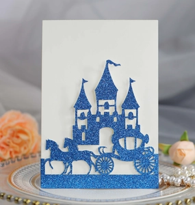 Detail of laser-cut glitter blue castle and carriage wedding invitation on silk