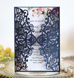 Detailed laser-cut navy blue wedding invitation with elegant floral watercolor insert