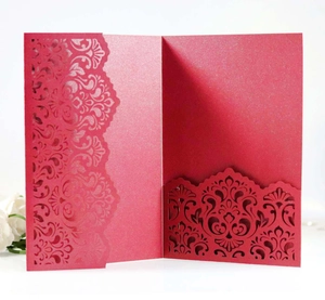 Macro detail of laser-cut floral patterns on dark red pearlescent card invitation