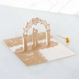 Detail of 3D laser cut wedding card with gold glitter finish and lace-like hollow edges