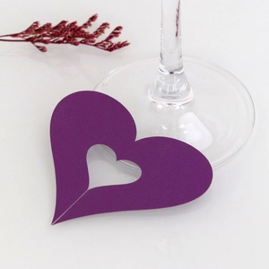 Close-up of purple heart-shaped laser-cut place card on a wine glass base