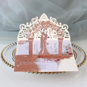 Détail d'un faire-part de mariage 3D en paillettes or rose avec silhouette de couple découpée