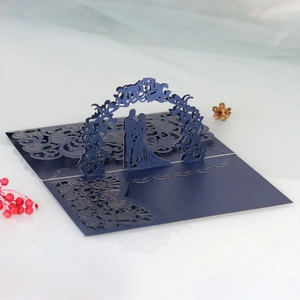 Détail d'un faire-part de mariage 3D découpé au laser avec couple sous une arche bleu marine