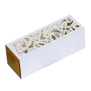 Detail of white gift box featuring gold laser-cut butterfly patterns and rectangular design