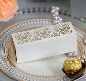 Detailed laser-cut heart pattern on white wedding favor box with gold liner detail