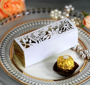 Detail of laser-cut hollow rose white gift box with gold liner on decorative plate