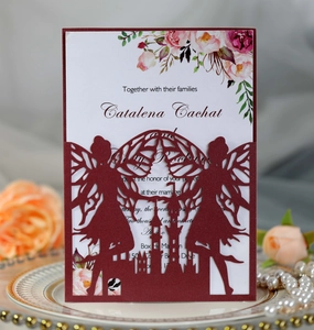 Detail view of burgundy laser-cut fairy castle invitation on elegant white plate