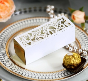 Detail of laser-cut butterfly hollow pattern on white and gold wedding candy favor box