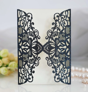 Detail of laser-cut navy blue glitter invitation card with elegant lace pattern and insert