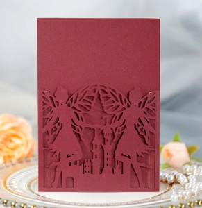 Detailed laser-cut burgundy invitation cover featuring a fairy and castle motif