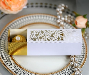 Detail of laser-cut butterfly gift box with white shell and gold liner on elegant plate