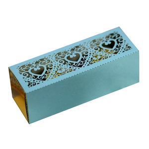 Detail of light blue gift box featuring laser-cut heart patterns and golden lining inside