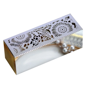 Detail of laser-cut geometric flower pattern on a metallic silver and gold gift box