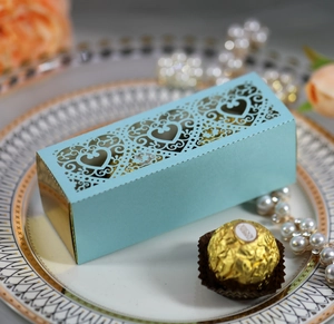 Detail of light blue laser-cut heart gift box with gold liner on an elegant white plate