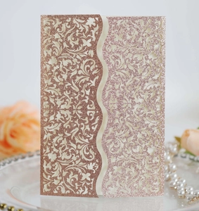 Macro shot of rose gold glitter laser-cut floral wedding invitation card detail