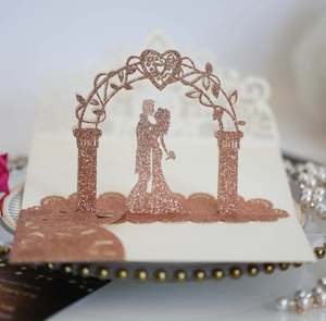 Détail d'une carte de mariage 3D découpée au laser montrant un couple sous une arche rose