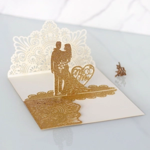 Dettaglio dell'invito di nozze tagliato al laser con glitter oro e motivo Mr & Mrs