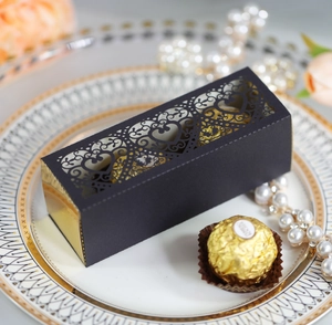 Detail of laser-cut heart pattern on elegant black and gold cardboard chocolate gift box