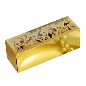 Detail of golden laser-cut butterfly wedding candy box with shiny mirror finish surface