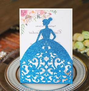 Macro shot of laser-cut glitter blue card invitation with elegant floral inner sheet