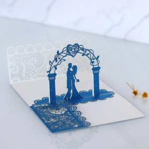 Detail view of 3D pop-up wedding card with laser-cut blue glitter lace and floral arch