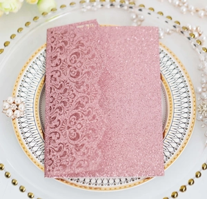 Close-up of pink glitter laser-cut invitation card with vintage floral hollow pattern