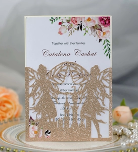 Close-up of laser-cut fairy and castle glitter wedding invitation with floral insert