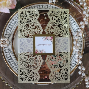Close-up of laser-cut gold glitter wedding invitation with mandala pattern and belly band