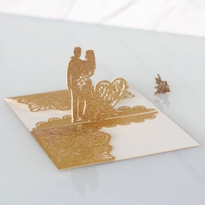 Dettaglio dell'invito di nozze 3D tagliato al laser con glitter dorati e silhouette