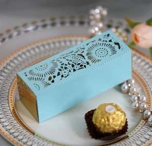 Detail of laser-cut hollow rose pattern on elegant blue gift box for wedding favors