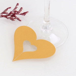 Close-up of elegant gold hollow heart place cards for wedding wine glass decoration