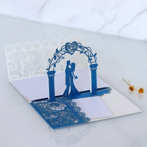 Detail of 3D laser-cut wedding invitation featuring blue glitter arch and lace pattern
