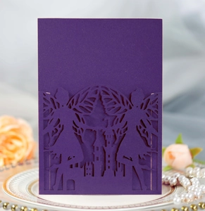 Close-up of laser-cut purple invitation featuring a fairy silhouette and castle pattern
