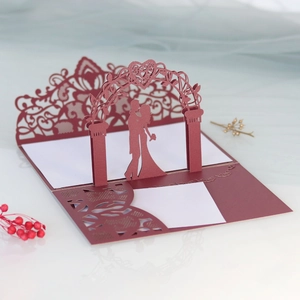 Macro detail of laser-cut burgundy wedding invitation with 3D pop-up bridal silhouette