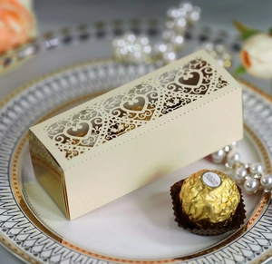 Detail of cream laser-cut gift box with intricate heart patterns and ornate vine edges
