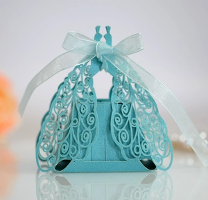 Detailed laser-cut peacock pattern on light blue favor box with ribbon bow and soft reflection