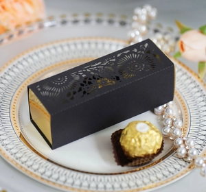 Detail of luxury laser-cut black flower gift box with gold interior and pearl accents