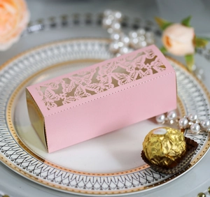 Macro shot of pink laser-cut butterfly gift box on elegant marble tray with pearls