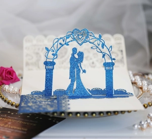Detail of laser cut 3D wedding invitation with blue glitter couple silhouette