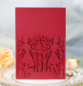 Detail of laser-cut burgundy invitation featuring castle and fairy silhouettes