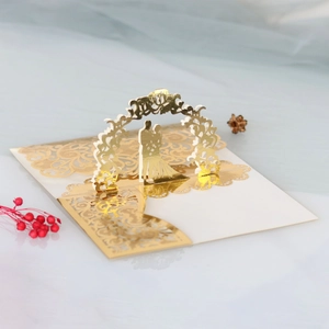Détail d'invitation de mariage 3D avec arche dorée et silhouette de couple découpée