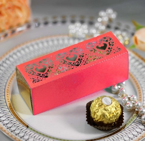 Macro detail of red laser-cut favor box with heart pattern and golden interior