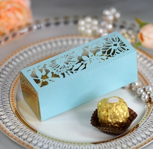 Macro detail of laser-cut floral pattern box with gold liner on a decorative plate