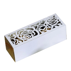 Detail of laser-cut rose pattern on white and gold rectangular wedding favor box