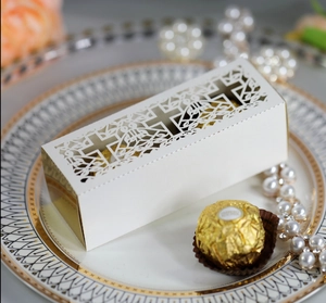 Detailed laser-cut white wedding gift box with cross pattern on decorative gold-lined plate