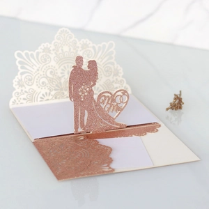 Dettaglio dell'invito di nozze laserato in oro rosa con silhouette Mr & Mrs